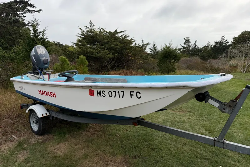 Slide: The Image of 1967 Boston Whaler 13 boat on trailer, labeled "MADASH," in grassy area. - 3