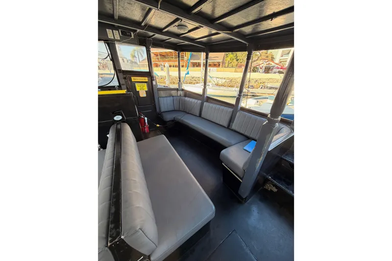 Slide: The Image of Interior of a 1983 Custom Limo Boat with gray seating and panoramic windows. - 14