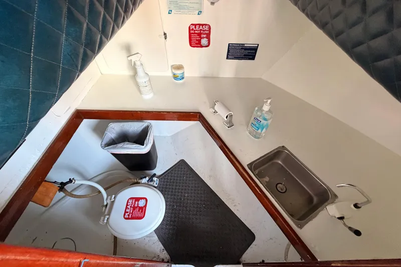 Slide: The Image of Interior of 1983 Custom Limo Boat bathroom with sink, sanitizer, and toilet. - 17