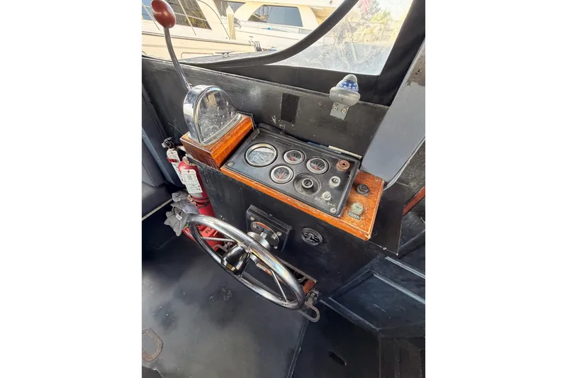 Slide: The Image of 1983 Custom Limo Boat dashboard with steering wheel, gauges, and controls. - 18