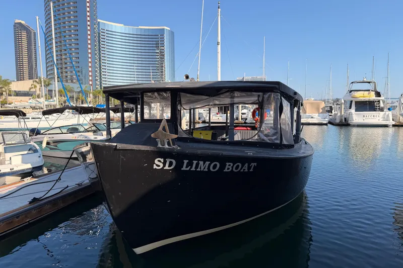 Slide: The Image of 1983 Custom Limo Boat docked in marina with modern buildings in background. - 4