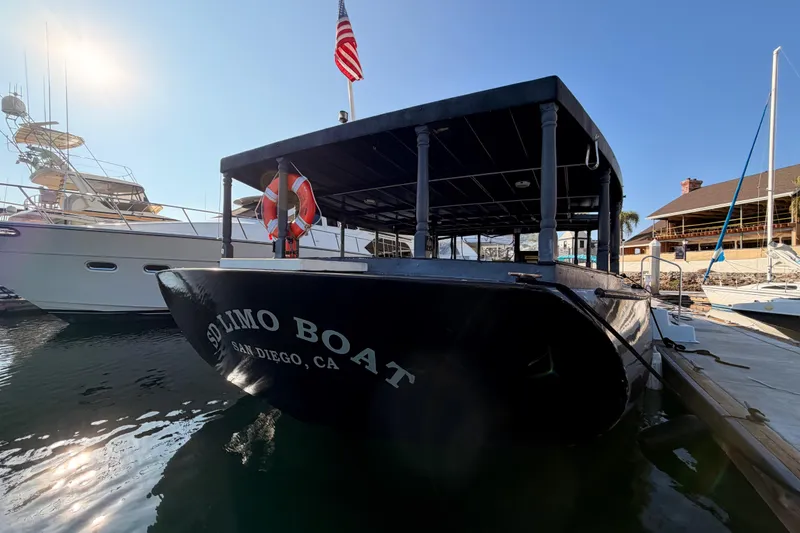 Slide: The Image of Custom 1983 Limo Boat docked in San Diego marina, with American flag. - 5