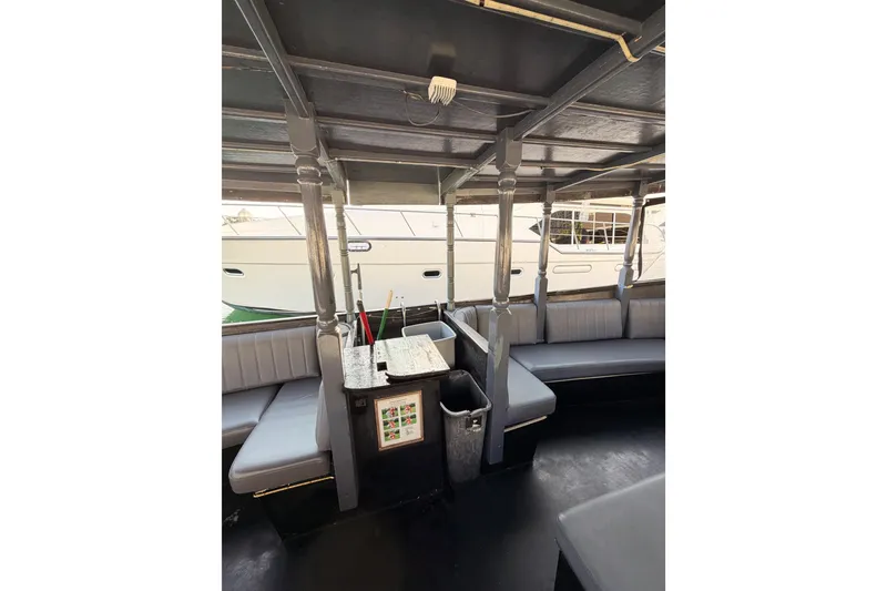 Slide: The Image of Interior of a 1983 Custom Limo Boat with gray seating and wooden details. - 9