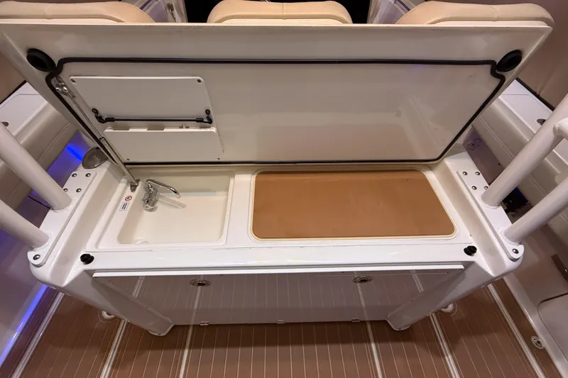 Slide: The Image of 2021 Cobia 350 CC boat interior with sink and cutting board. - 13
