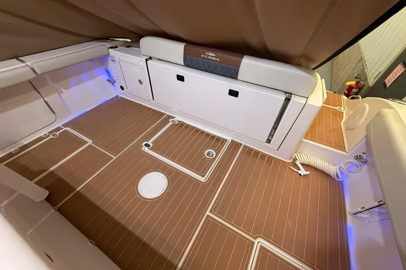 Slide: The Image of 2021 Cobia 350 CC boat interior with cushioned seating and wood-patterned flooring. - 15