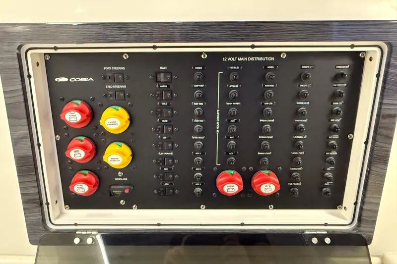 Slide: The Image of Electrical control panel of a 2021 Cobia 350 CC boat, featuring switches and circuit breakers. - 21