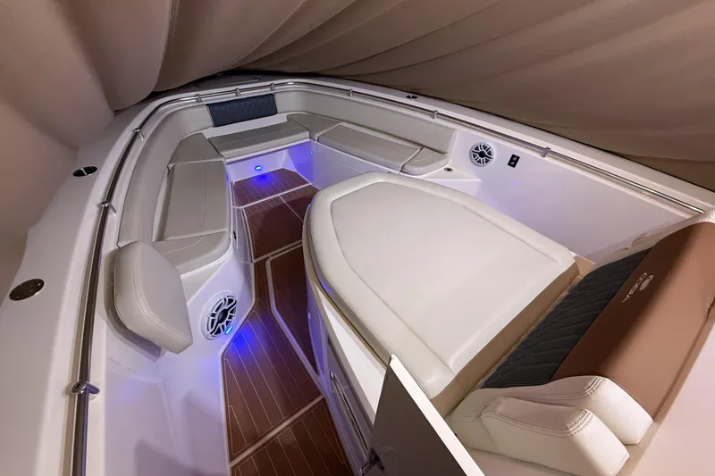 Slide: The Image of 2021 Cobia 350 CC boat interior with cushioned seating and ambient lighting. - 22