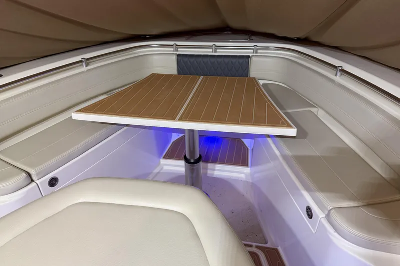 Slide: The Image of 2021 Cobia 350 CC boat interior with seating and wooden table. - 25