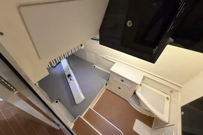 Slide: The Image of Interior cabin of 2021 Cobia 350 CC boat, featuring compact bathroom and storage area. - 30