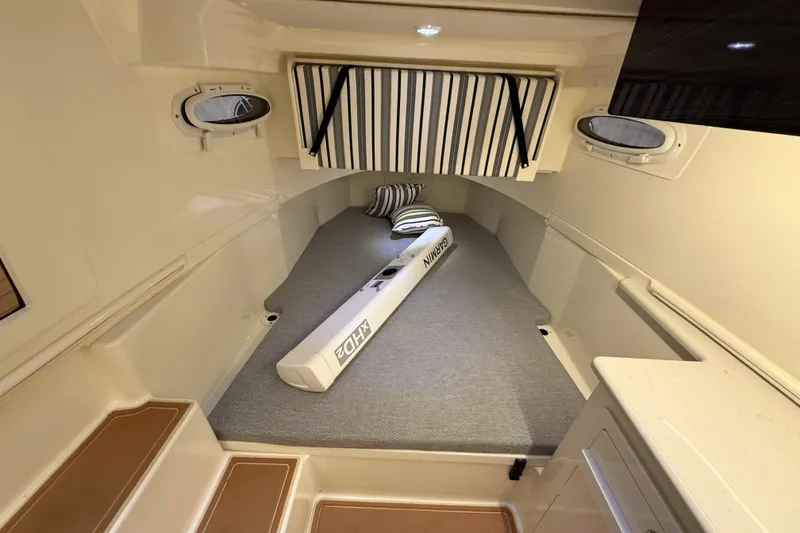 Slide: The Image of 2021 Cobia 350 CC cabin interior with striped cushions and portholes. - 31