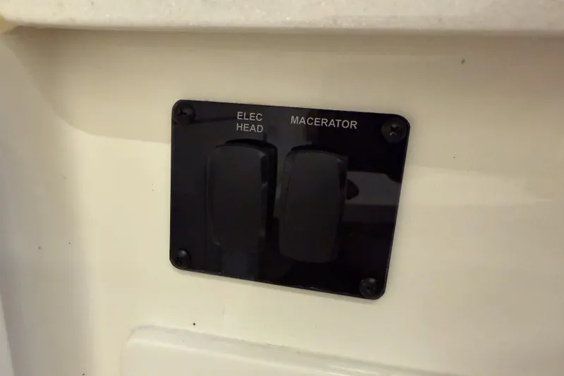 Slide: The Image of Control panel for electric head and macerator on 2021 Cobia 350 CC boat. - 32