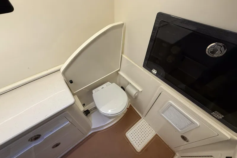 Slide: The Image of 2021 Cobia 350 CC boat bathroom interior with toilet and storage compartments. - 33