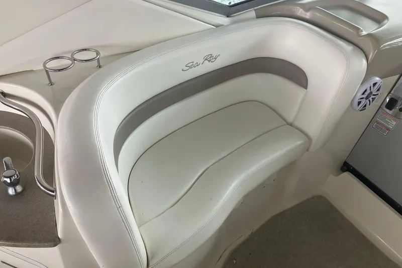 Slide: The Image of 2004 Sea Ray 320 Sundancer boat interior with white seating and cup holders. - 12