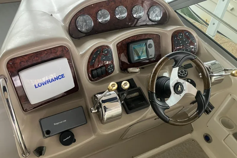 Slide: The Image of Helm of 2004 Sea Ray 320 Sundancer with Lowrance navigation system and wood-accented dashboard. - 14