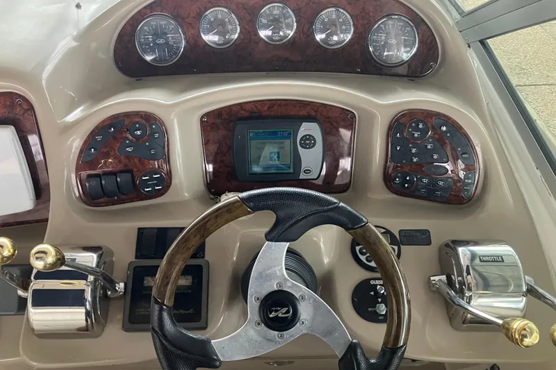 Slide: The Image of 2004 Sea Ray 320 Sundancer dashboard with steering wheel and control panel. - 15