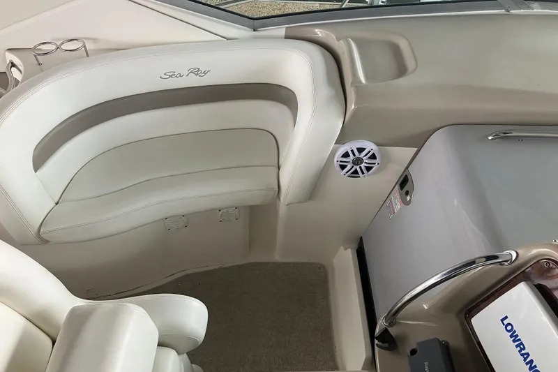 Slide: The Image of 2004 Sea Ray 320 Sundancer interior with white seating and navigation equipment. - 17