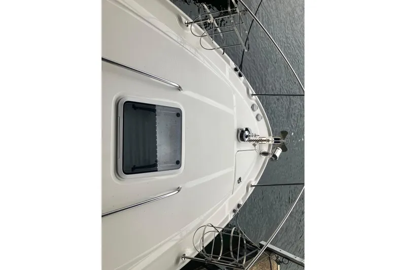 Slide: The Image of 2004 Sea Ray 320 Sundancer boat deck with hatch and railing, docked on water. - 20