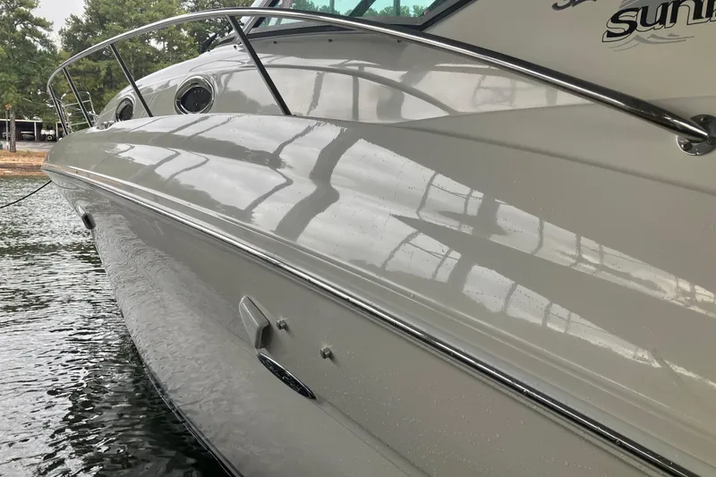 Slide: The Image of 2004 Sea Ray 320 Sundancer boat docked on calm water. - 28