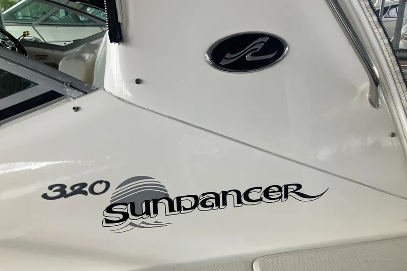 Slide: The Image of 2004 Sea Ray 320 Sundancer boat logo and model name on white hull. - 29
