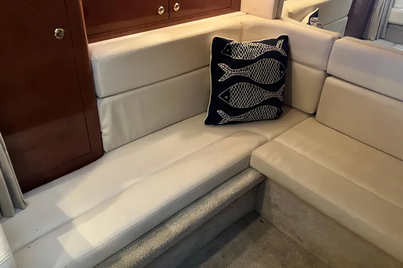Slide: The Image of 2004 Sea Ray 320 Sundancer interior with beige seating and decorative fish pillow. - 31