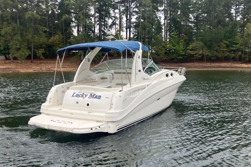 Slide: The Image of 2004 Sea Ray 320 Sundancer boat on a lake with forested shoreline. - 5