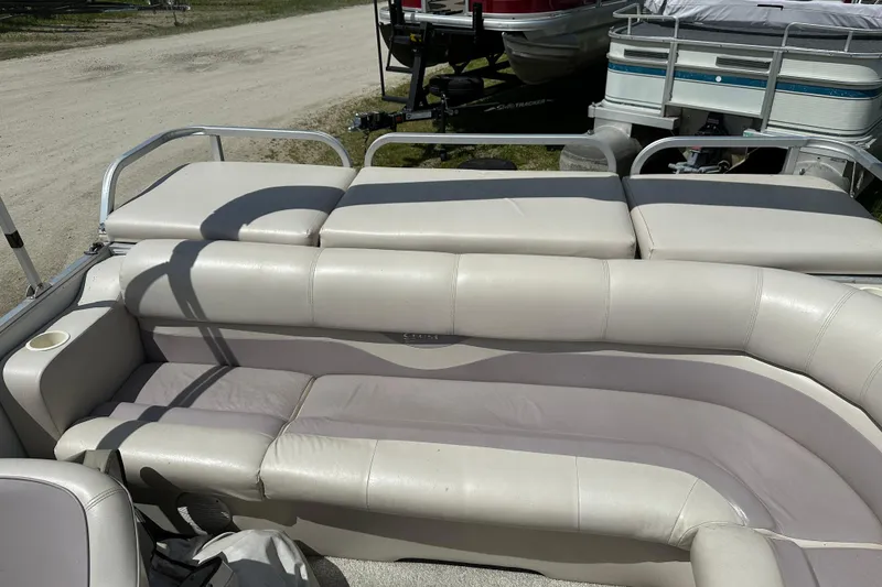 Slide: The Image of 2003 Crest 25 II LM pontoon boat interior with beige seating and cup holder. - 15