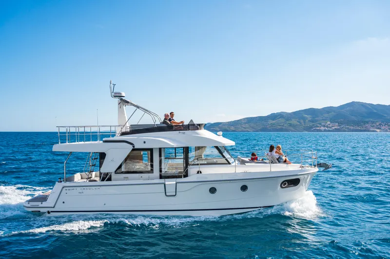 The Image of 2025 Beneteau Swift Trawler 41 Fly cruising on open sea with passengers onboard. - 0