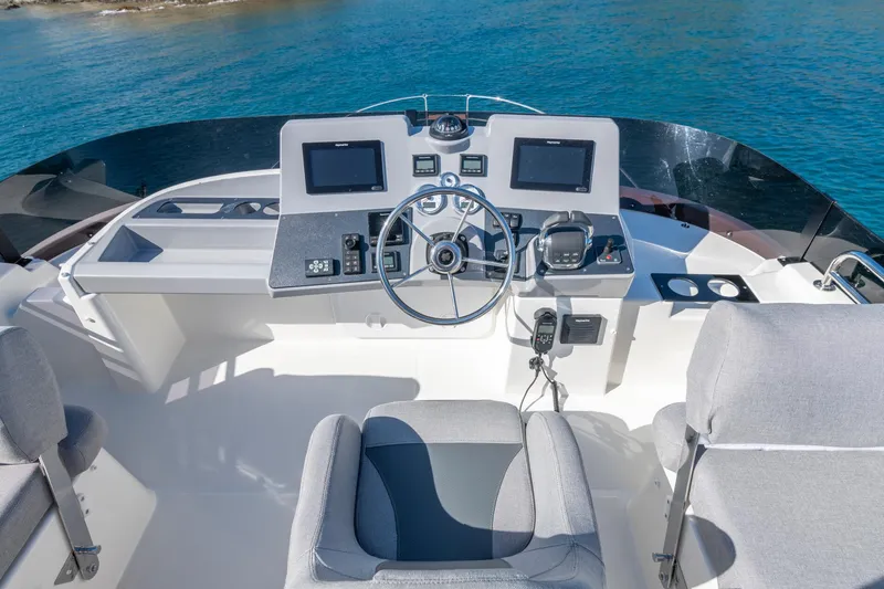 Slide: The Image of 2025 Beneteau Swift Trawler 41 Fly helm with dual screens and modern controls. - 13