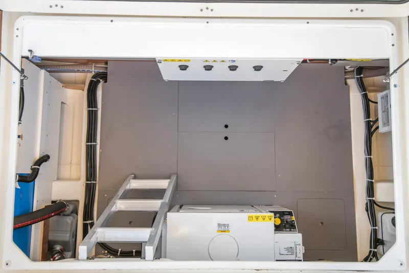 Slide: The Image of Engine room of 2025 Beneteau Swift Trawler 41 Fly, featuring equipment and ladder. - 16