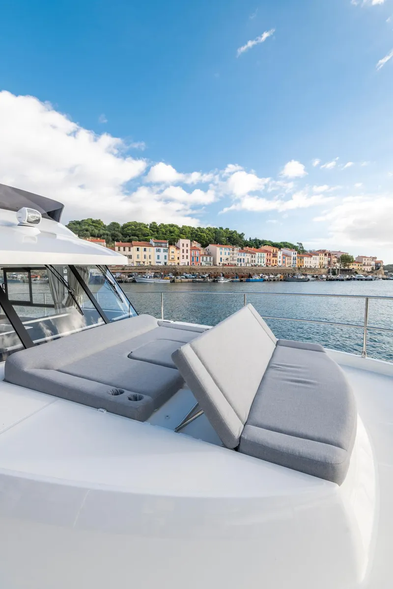 Slide: The Image of 2025 Beneteau Swift Trawler 41 Fly with sunbed, coastal view, and blue sky. - 14
