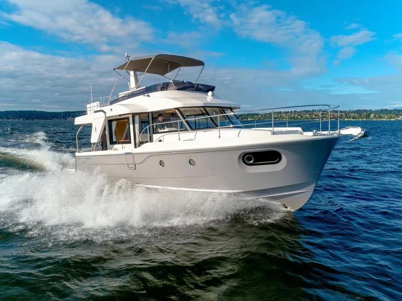 Slide: The Image of 2025 Beneteau Swift Trawler 41 Fly cruising on open water under a clear blue sky. - 3