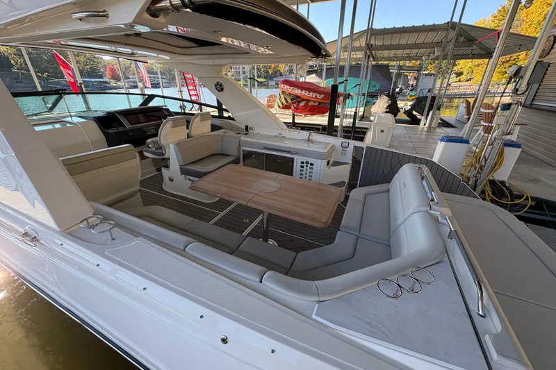 Slide: The Image of 2023 Sea Ray SLX 400 boat interior with seating, table, and kitchenette. - 28