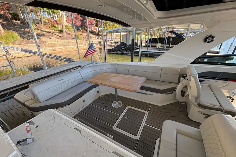 Slide: The Image of Luxurious 2023 Sea Ray SLX 400 boat interior with seating and table, docked at marina. - 29
