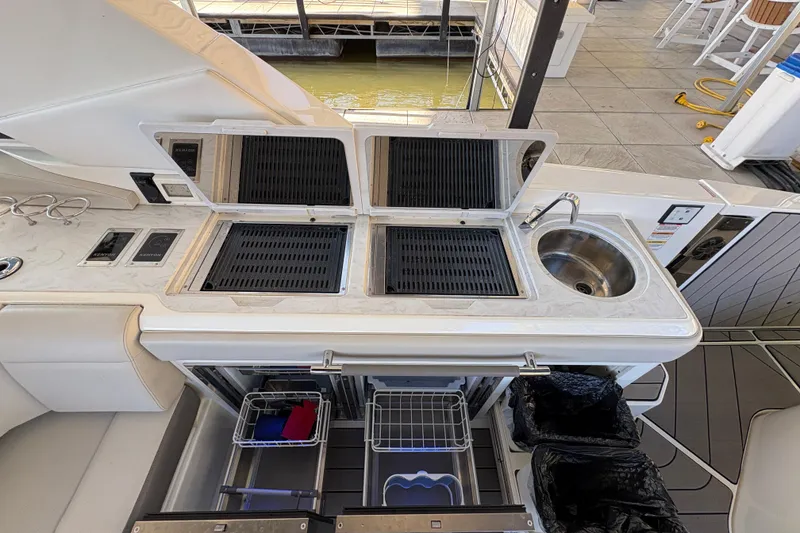 Slide: The Image of 2023 Sea Ray SLX 400 yacht kitchen with dual grills and storage cabinets. - 33
