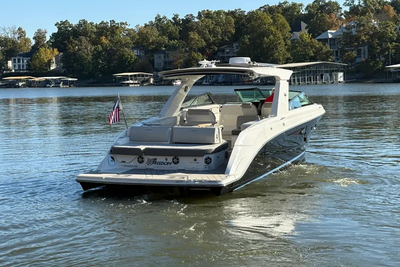 Slide: The Image of 2023 Sea Ray SLX 400 boat cruising on a serene lake with scenic background. - 5