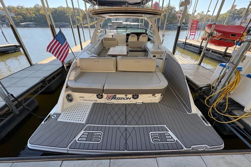 Slide: The Image of 2023 Sea Ray SLX 400 luxury boat cruising on a serene lake. - 8