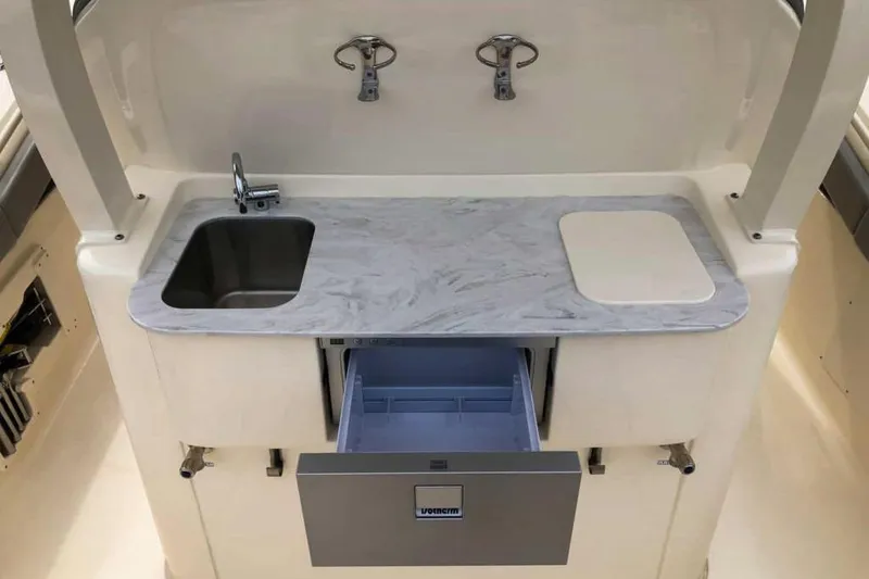 Slide: The Image of Manufacturer Provided Image: 2025 Scout 330 LXF boat kitchen with sink, cutting board, and storage drawer. - 9