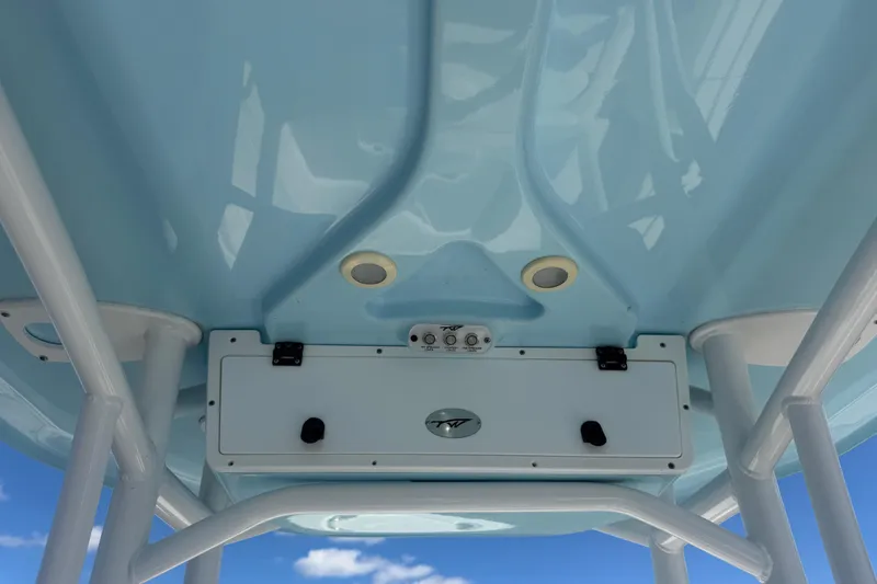 Slide: The Image of 2020 Tidewater 2300 Carolina Bay boat, blue T-top underside, white frame, clear sky background. - 17