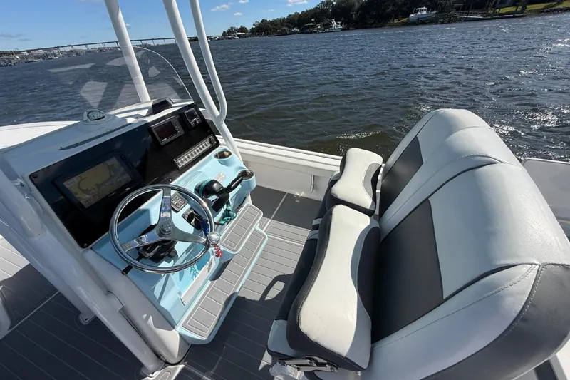 Slide: The Image of 2020 Tidewater 2300 Carolina Bay boat interior with steering console and seating, on a scenic waterway. - 30