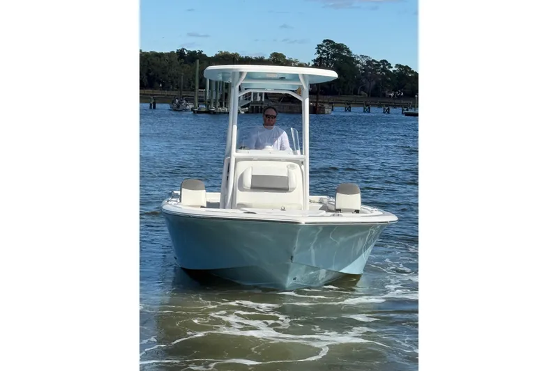 Slide: The Image of 2020 Tidewater 2300 Carolina Bay boat on water, with a person at the helm. - 9