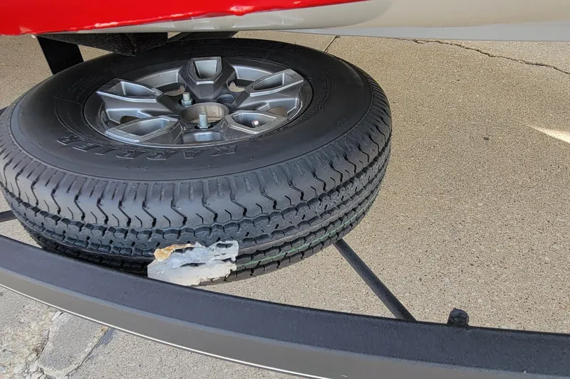 Slide: The Image of Bass Tracker Pro Team 175 XTE 2022 trailer tire with visible damage on concrete surface. - 7