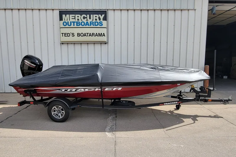 Slide: The Image of 2022 Bass Tracker Pro Team 175 XTE boat covered, parked at Ted's Boatarama. - 2