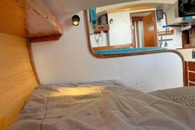 Slide: The Image of Interior of a 1965 Pearson Alberg 35 sailboat, featuring cozy wooden cabin and bedding. - 13