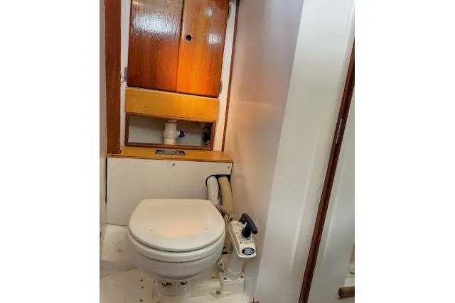 Slide: The Image of 1965 Pearson Alberg 35 yacht bathroom with wooden cabinet and marine toilet. - 16