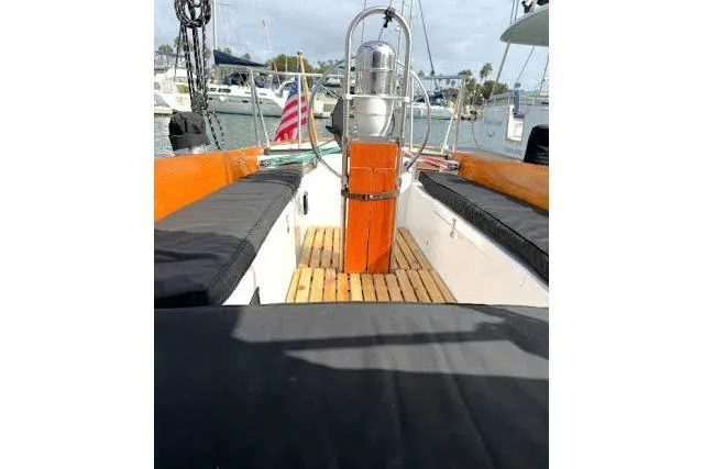 Slide: The Image of 1965 Pearson Alberg 35 sailboat cockpit with wooden flooring and seating, docked at marina. - 19