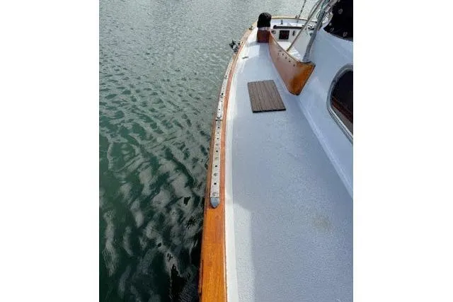Slide: The Image of 1965 Pearson Alberg 35 sailboat deck with wooden trim on calm water. - 24