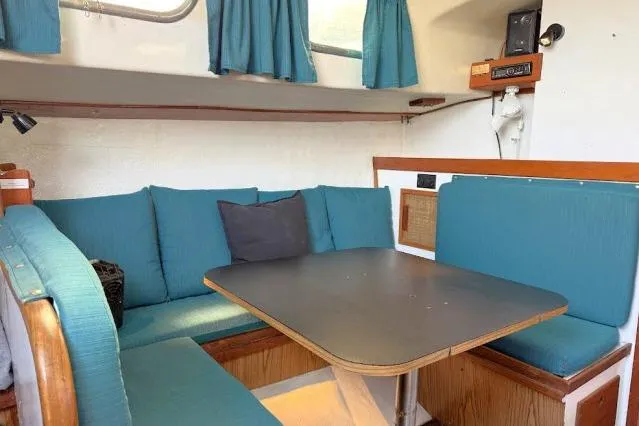 Slide: The Image of Interior of a 1965 Pearson Alberg 35 sailboat with teal seating and a wooden table. - 3