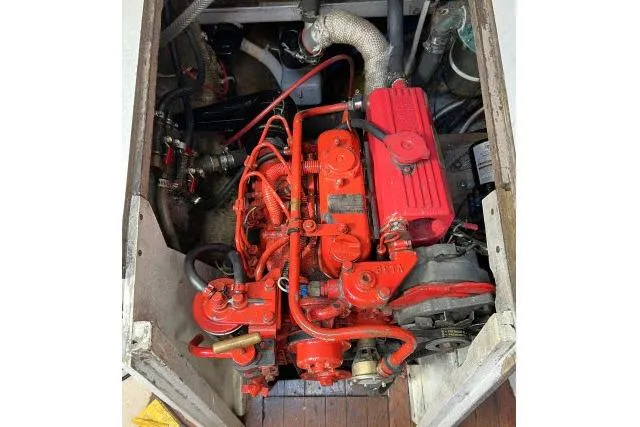Slide: The Image of Engine compartment of a 1965 Pearson Alberg 35 sailboat, featuring a red-painted engine. - 31