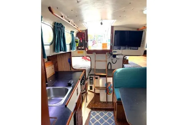 Slide: The Image of Interior of a 1965 Pearson Alberg 35 sailboat with kitchen and seating area. - 6