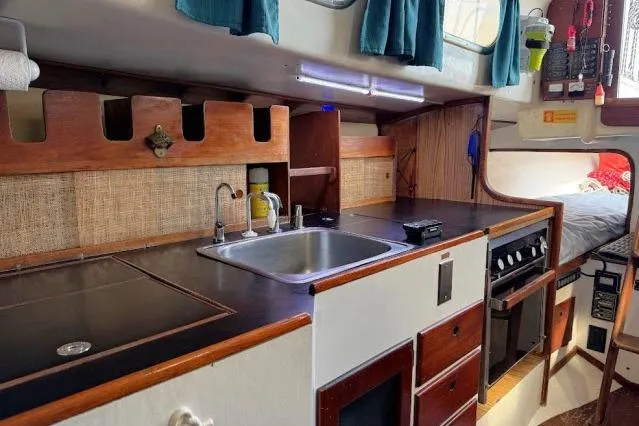 Slide: The Image of 1965 Pearson Alberg 35 yacht interior with kitchen, sink, stove, and cozy sleeping area. - 7